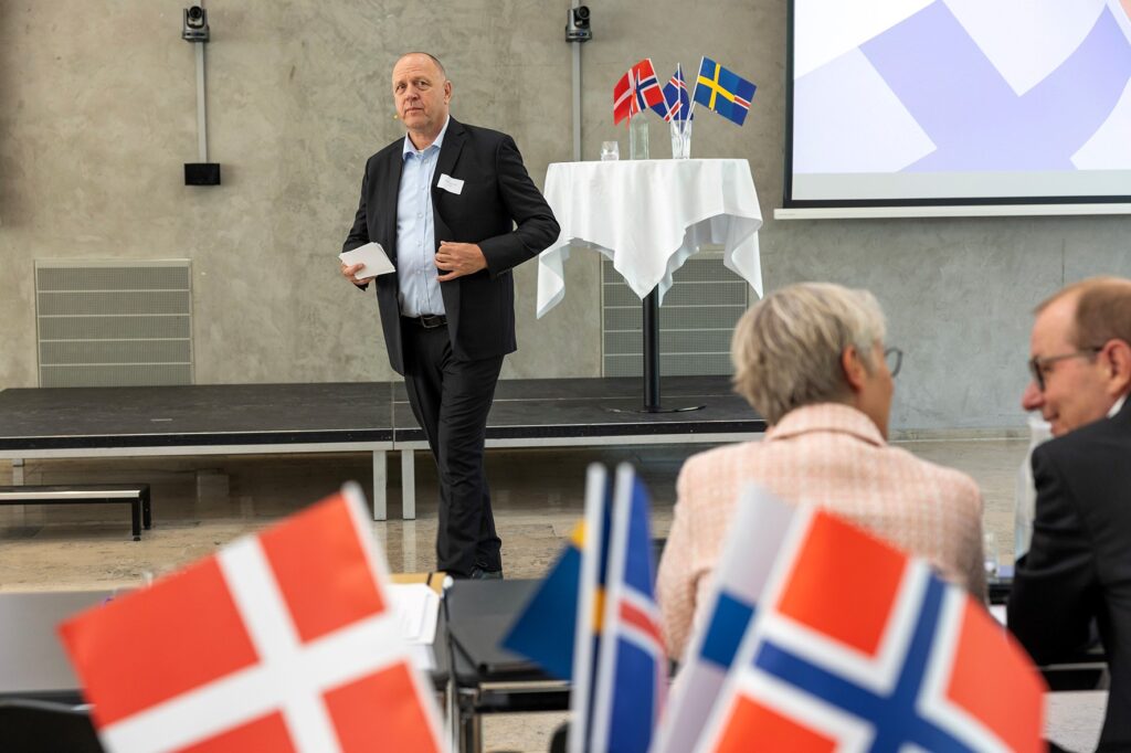 A man in a suit in front of an audience.